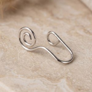 پیرسینگ فیک بینی نقره ای طرح مارپیچ روی زمینه روشن سنگی
