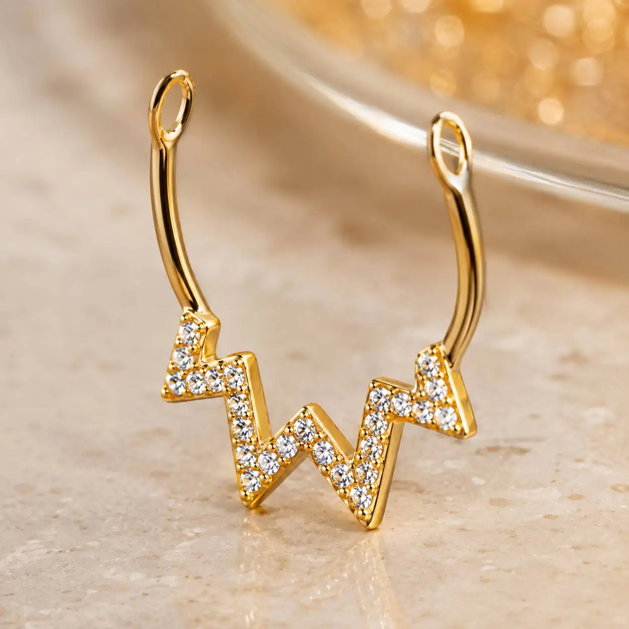 gold-heartbeat-fake-septum-jewelry نمای نزدیک پیرسینگ فیک سپتوم طلایی زیگزاگی با نگینهای ریز درخشان