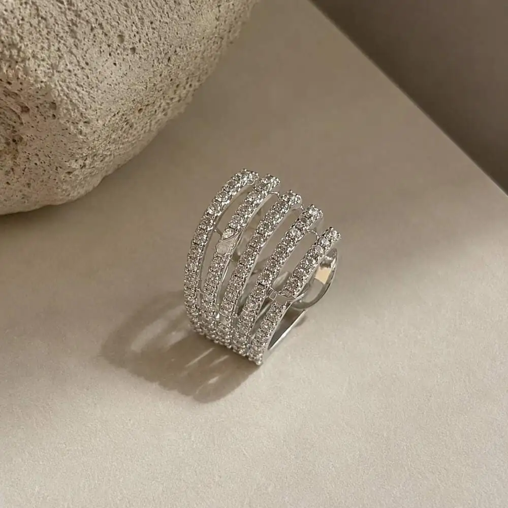 silver-multi-row-earcuff نمای نزدیک ایرکاف کریستالی چند لایه روی پسزمینه مینیمال
