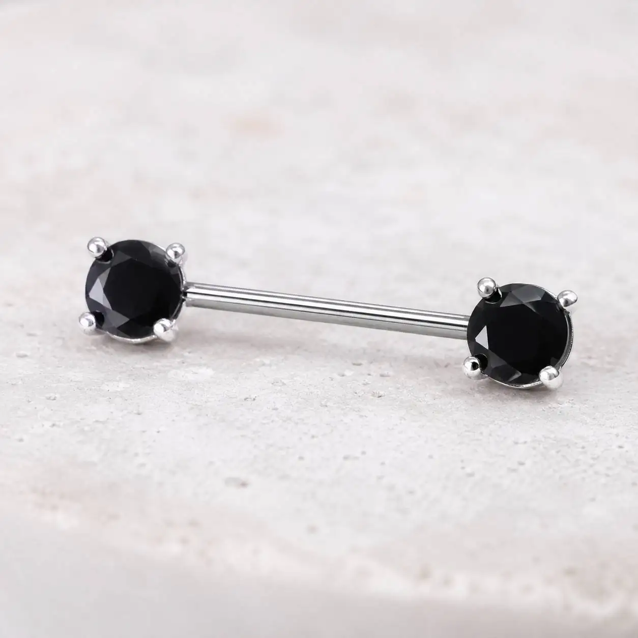 black-gem-nipple-barbell-closeup نمای نزدیک پیرسینگ نیپل نقرهای با دو نگین مشکی گرد