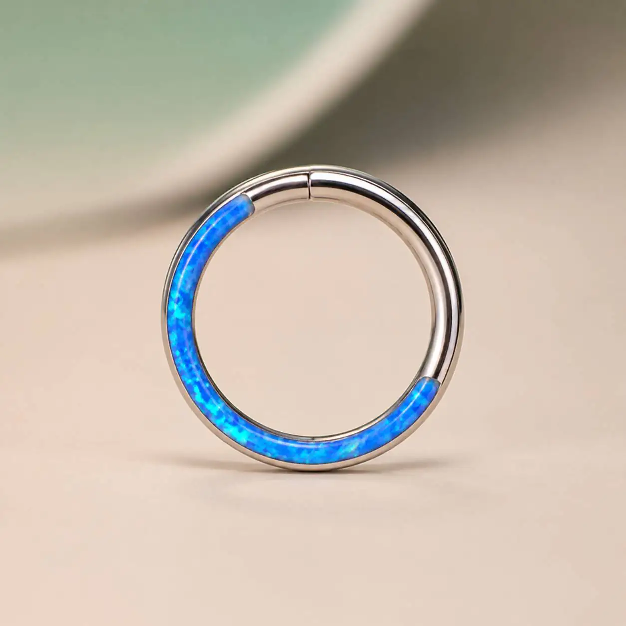 blue-opal-septum-hoop-front-view تصویر نمای روبهرو از پیرسینگ سپتوم حلقهای نقرهای با سنگ اوپال آبی اصل