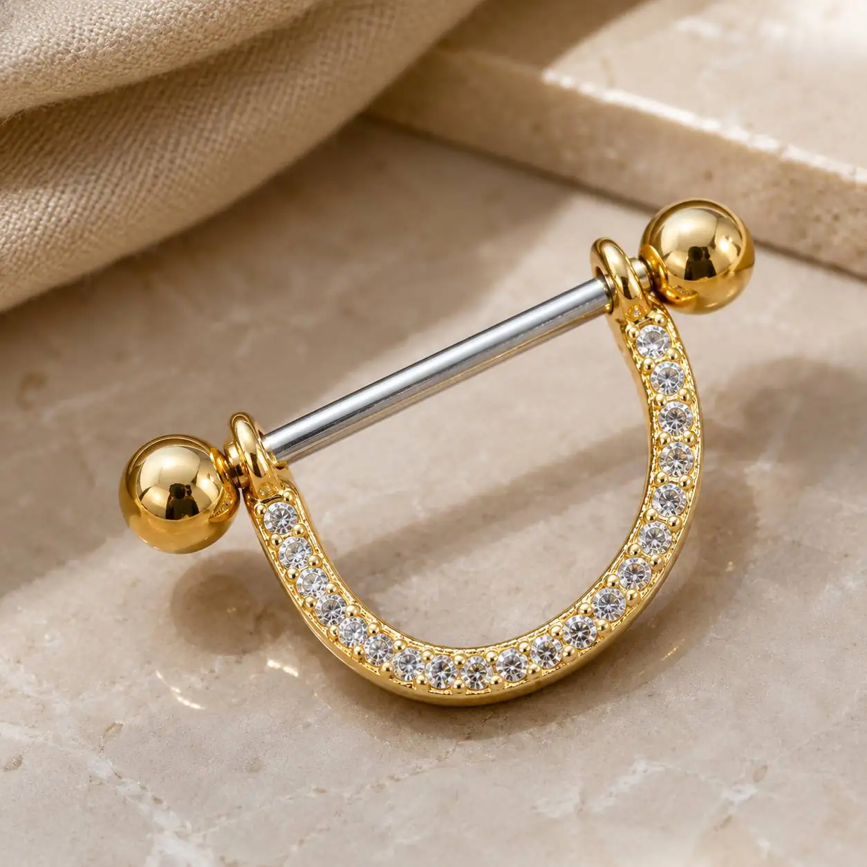crescent-nipple-barbell-jewelry-closeup نمای نزدیک پیرسینگ نیپل دو رنگ با هلال طلایی و نگینهای شفاف