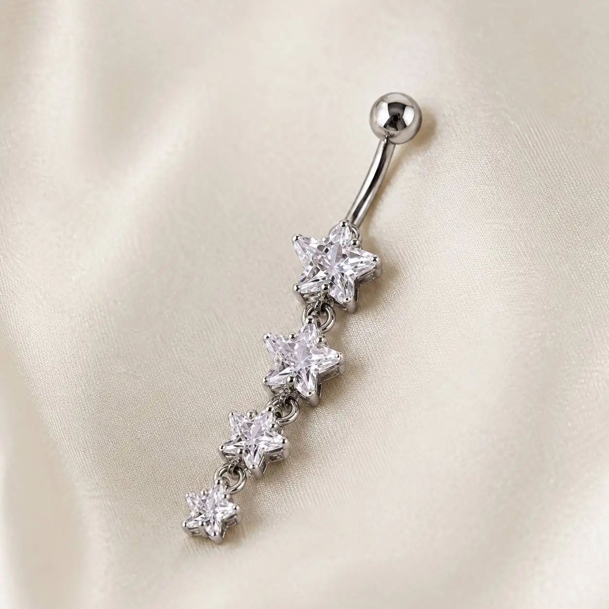 four-star-belly-button-ring-side-view نمای زاویهدار پیرسینگ ناف با میله منحنی و نگینهای ستارهای شفاف
