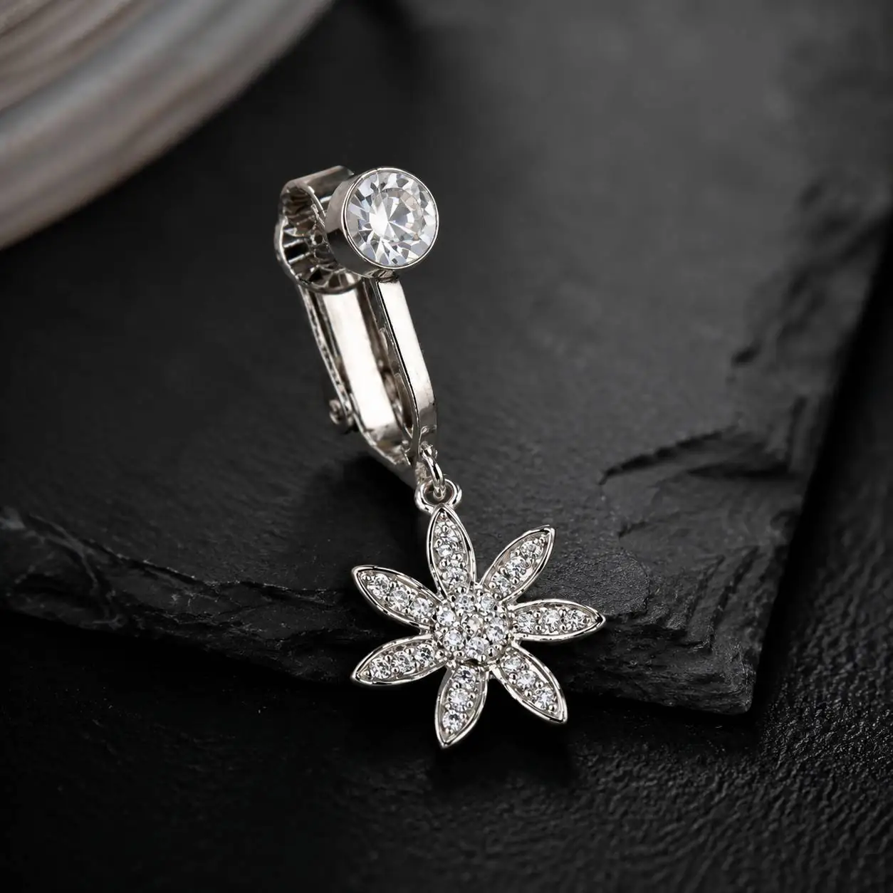 gemstone-flower-clip-on-navel-jewelry.jpg نمای نزدیک پیرسینگ فیک ناف گلدار با طراحی کریستالی و گیره بدون سوراخ