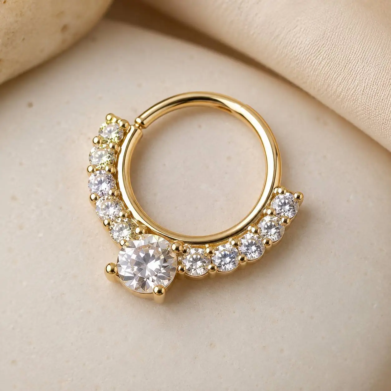 gold-septum-clicker-crystal-jewelry-flatlay عکس محصول پیرسینگ سپتوم طلایی کریستالی روی پسزمینه روشن با ظاهر لوکس و مینیمال