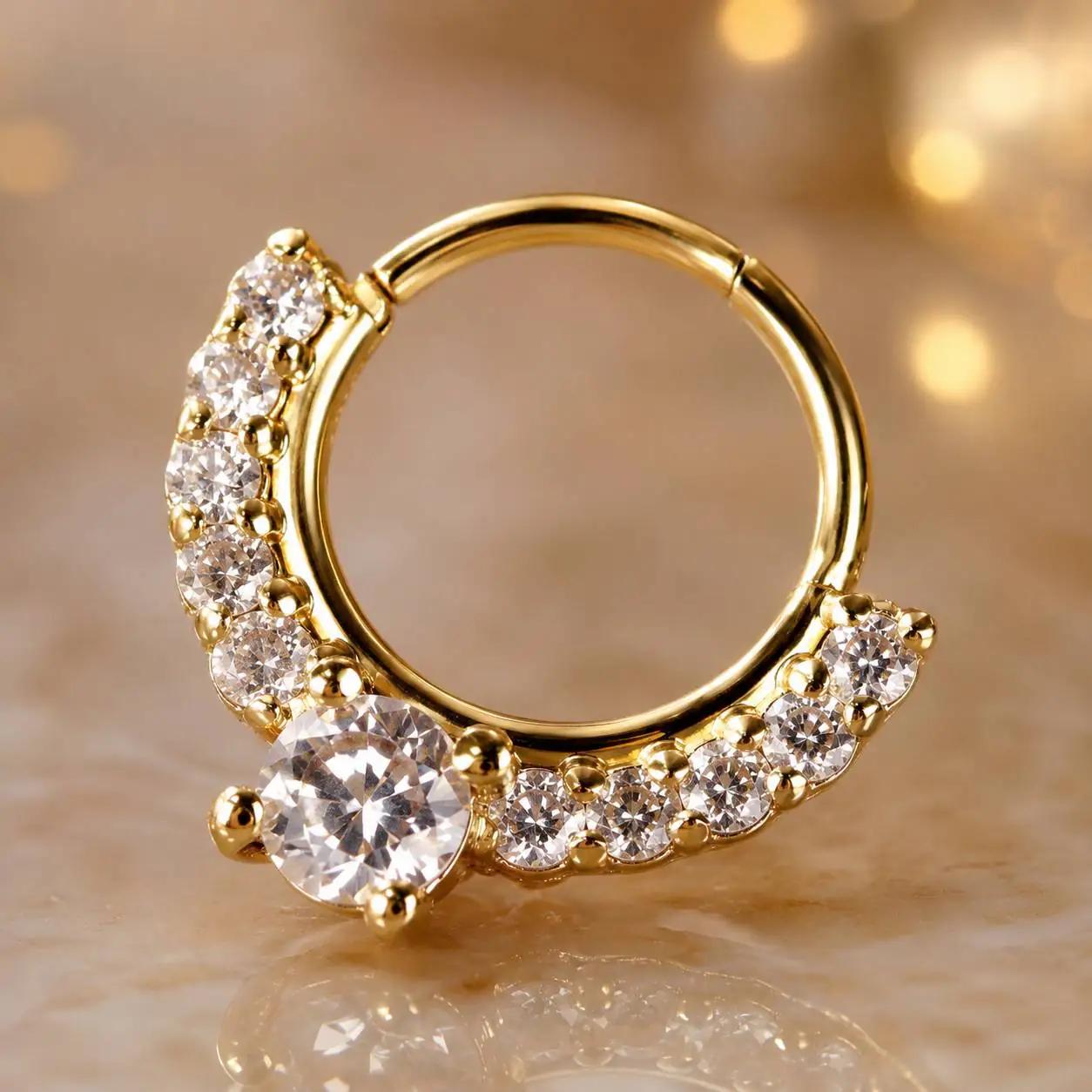 luxury-gold-septum-ring-gemstone-side-view نمای نزدیک از پیرسینگ سپتوم کلیکری طلایی با بدنه حلقهای ظریف و نگینهای شفاف