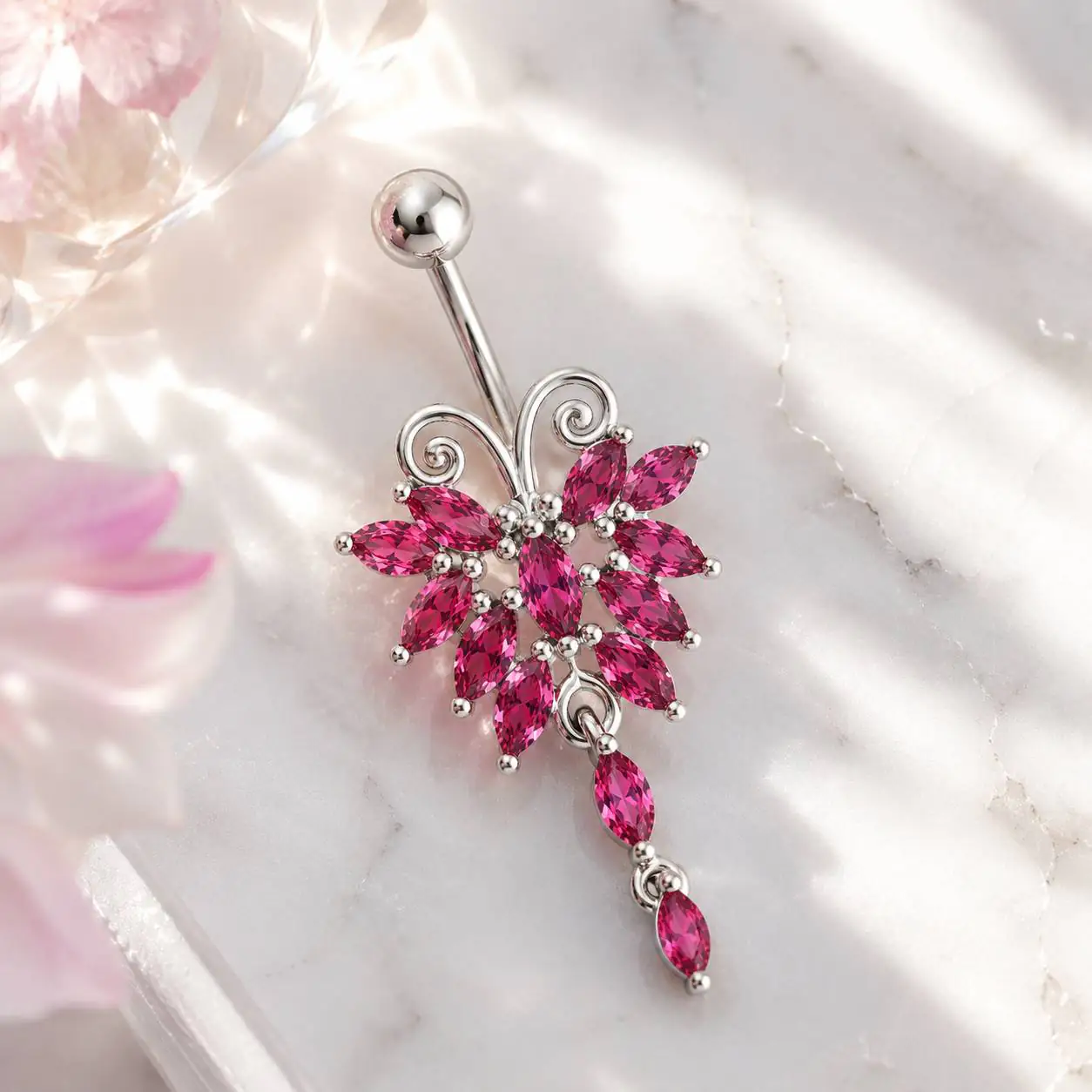 pink-floral-navel-ring-marble-background پیرسینگ نگیندار ناف صورتی با طراحی گل و آویز انتهایی