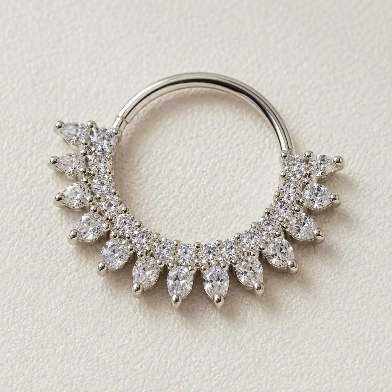 silver-crystal-crown-septum-piercing-front پیرسینگ سپتوم نقرهای نگیندار مدل تاجی با نگینهای شفاف روی پسزمینه روشن