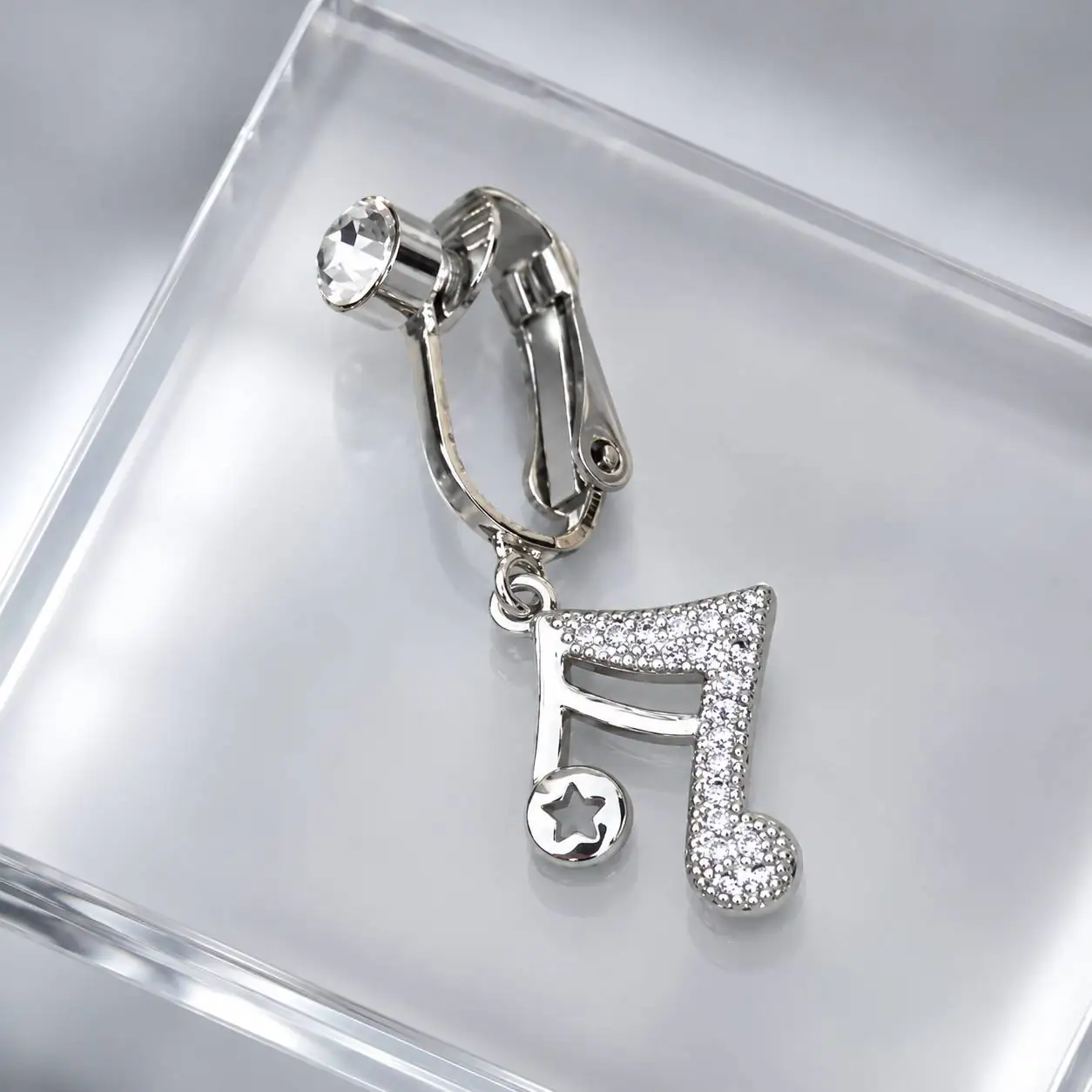 silver-rhinestone-fake-belly-piercing-side.jpg نمای زاویهدار پیرسینگ فیک ناف کلیپسی با نگین شفاف و آویز نت موسیقی