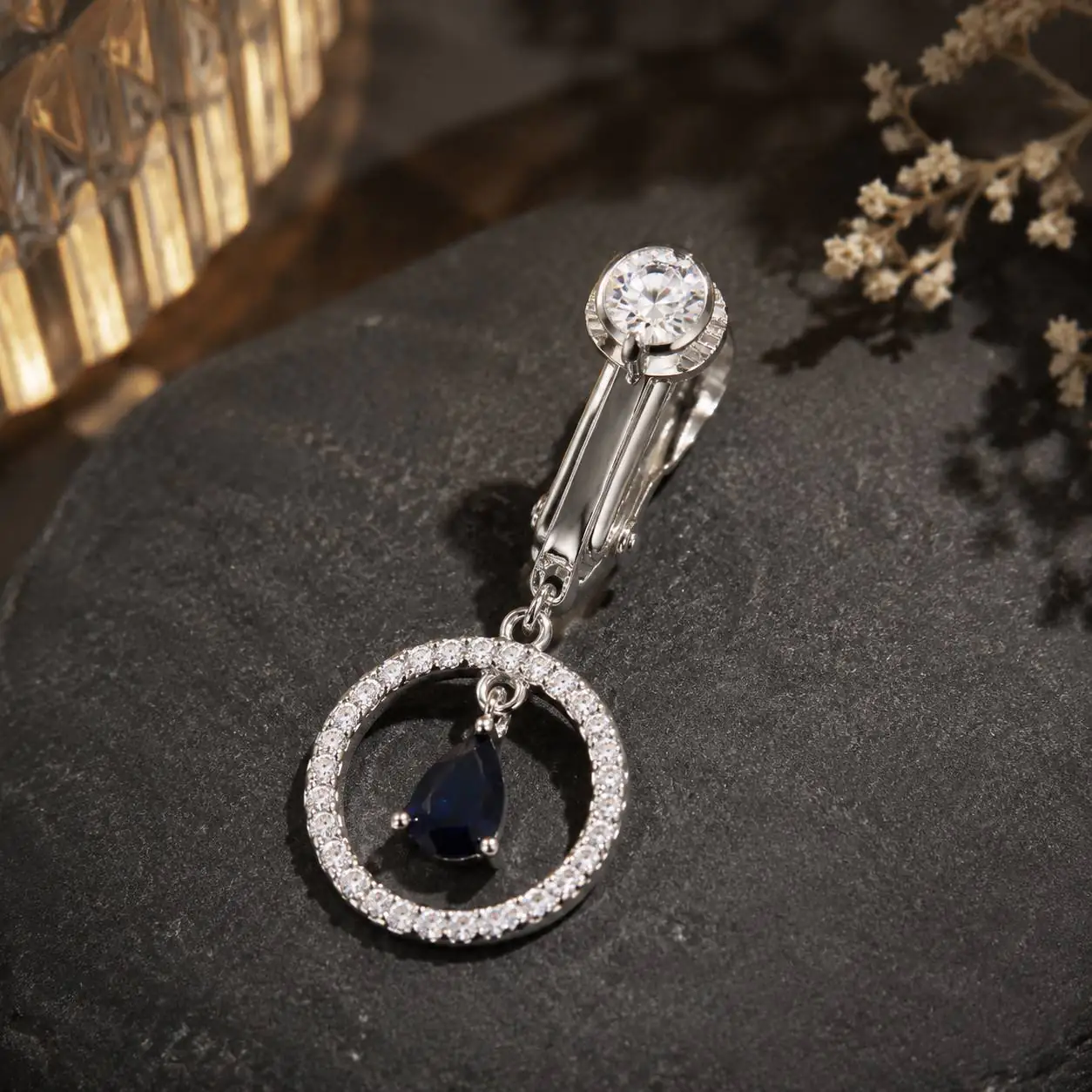 silver-ring-navel-piercing-jewelry-closeup نمای نزدیک پیرسینگ فیک ناف حلقهای نگیندار با طراحی لوکس و آویز آبی