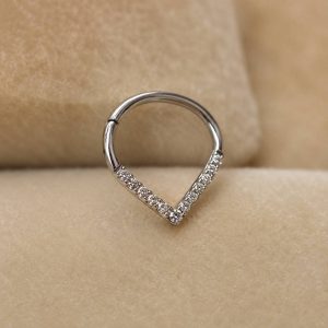پیرسینگ سپتوم نقره‌ای نگین‌دار طرح اشکی روی زمینه مخملی کرم