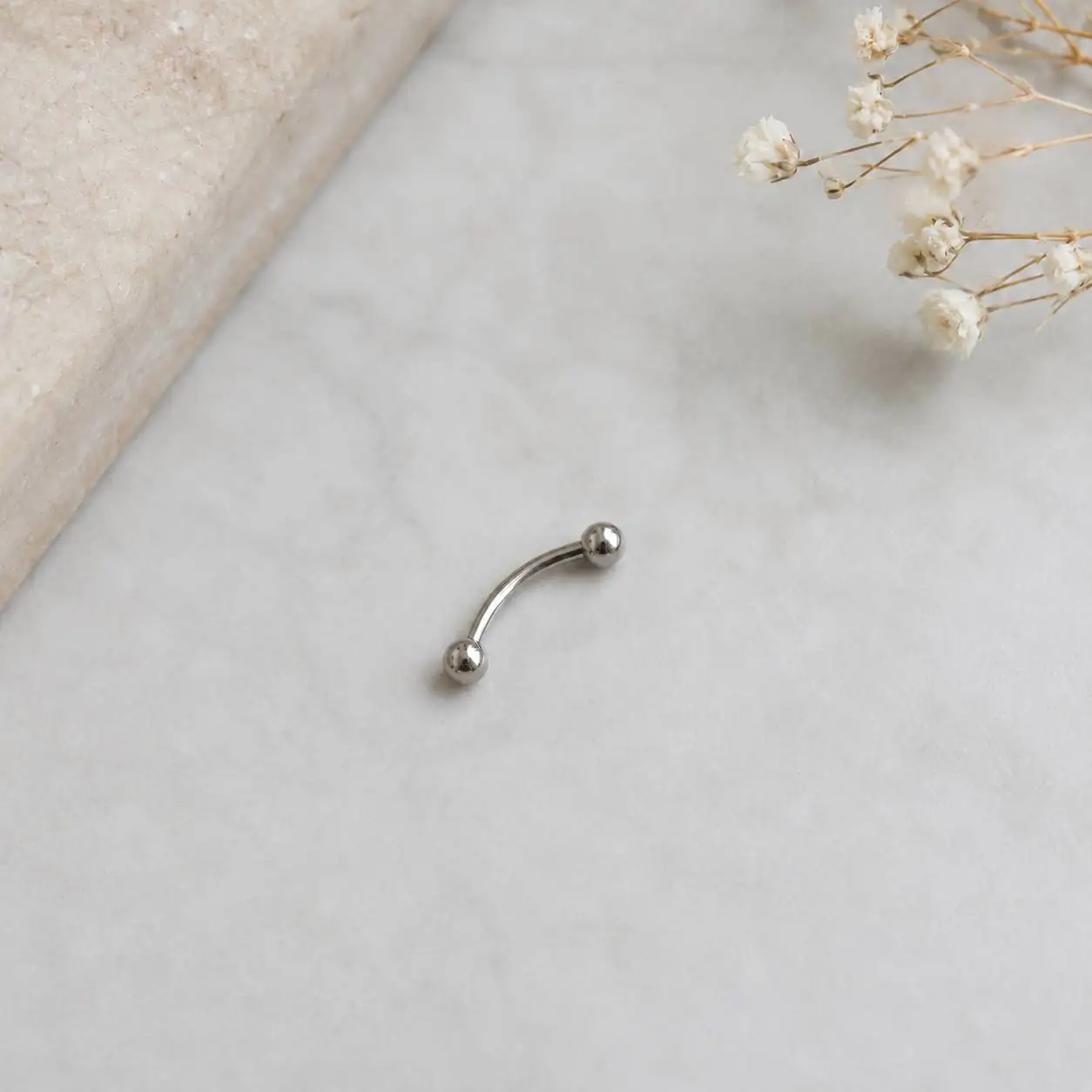 titanium-eyebrow-barbell-product-photo.jpg تصویر محصول پیرسینگ ابرو تیتانیومی نقرهای مدل ساده و بدون نگین