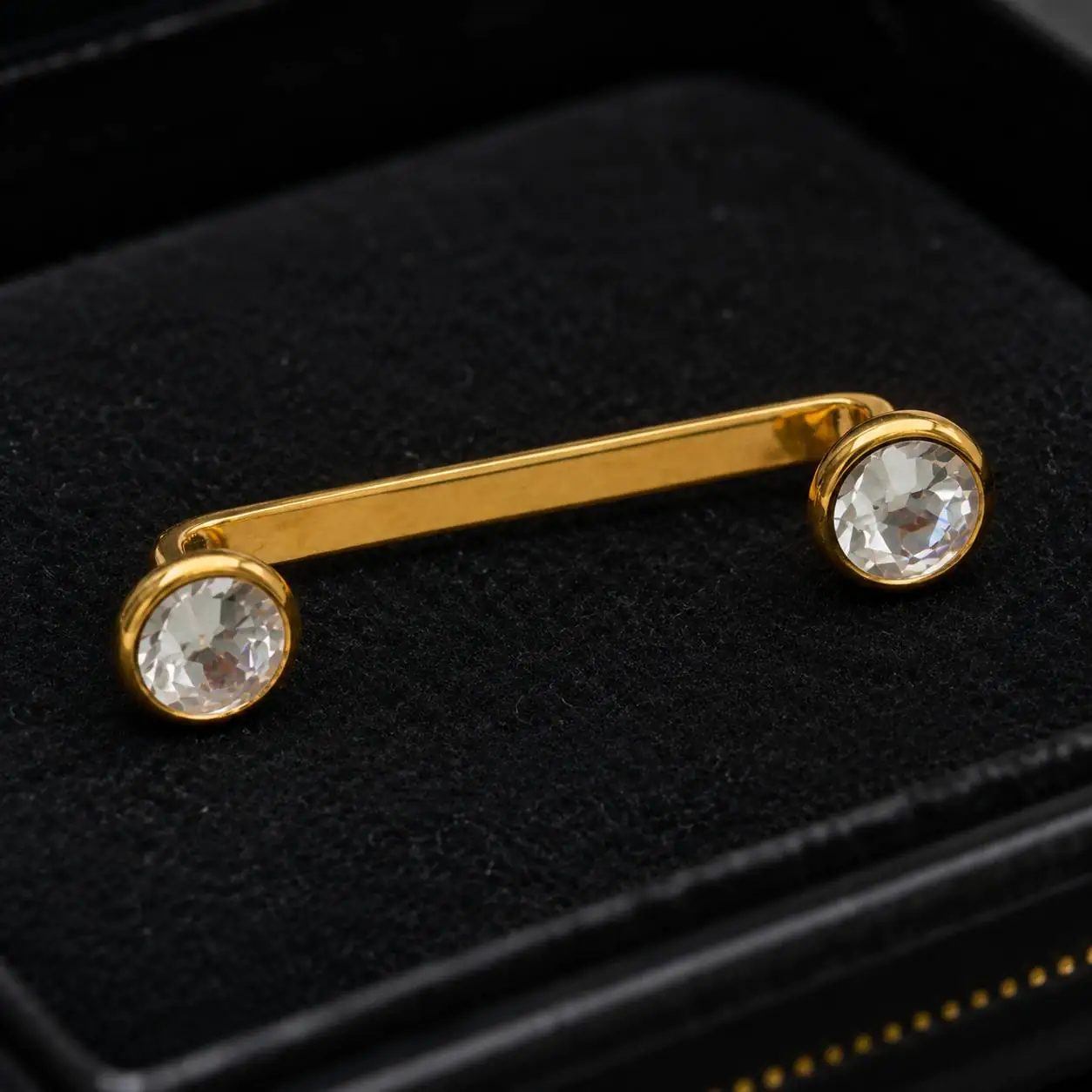 clavicle-surface-bar-clear-gems نمای نزدیک پیرسینگ Surface Bar نگیندار با میله طلایی