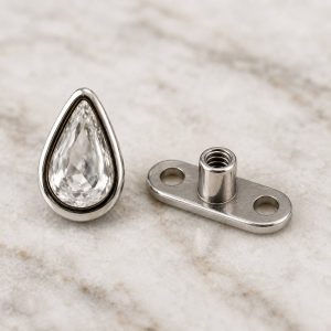 پیرسینگ میکرودرمال نگین اشکی شفاف با فریم نقره‌ای از نمای روبه‌رو