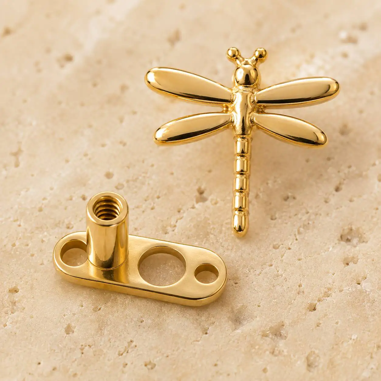 gold-microdermal-dragonfly-jewelry نمای نزدیک پیرسینگ میکرودرمال طرح سنجاقک طلایی و پایه آن