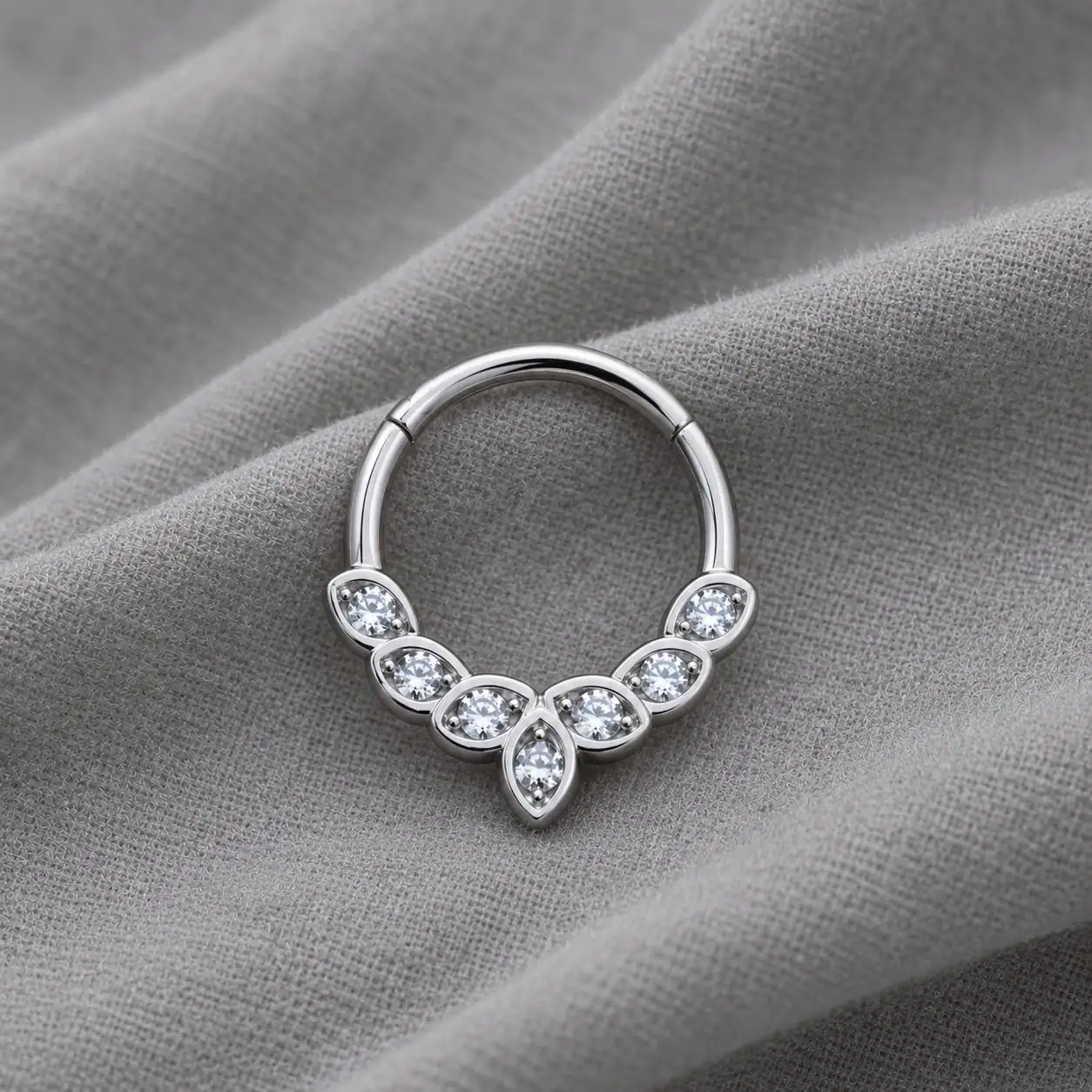leaf-gem-septum-piercing-black-velvet نمای نزدیک پیرسینگ سپتوم نقرهای نگیندار طرح برگ روی پارچه مخمل مشکی