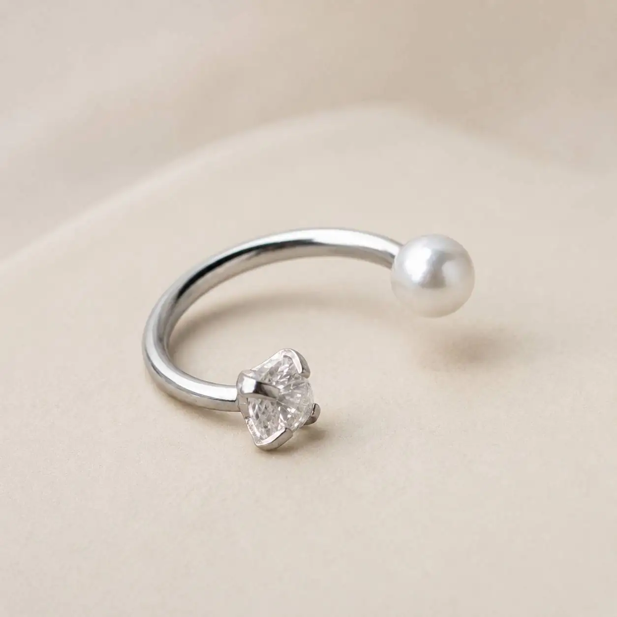 pearl-gem-smiley-piercing-side-view.jpg نمای بالا از پیرسینگ اسمایل حلقهای نقرهای نگیندار و مرواریدی
