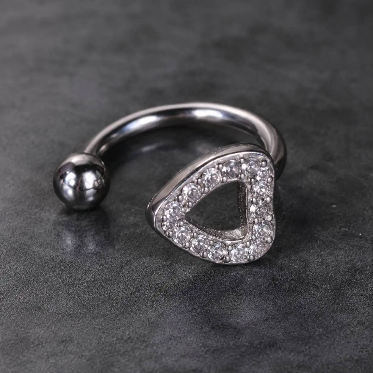 rhinestone-triangle-smiley-piercing-closeup پیرسینگ اسمایل مثلثی نگیندار با گوی فلزی روی پسزمینه تیره
