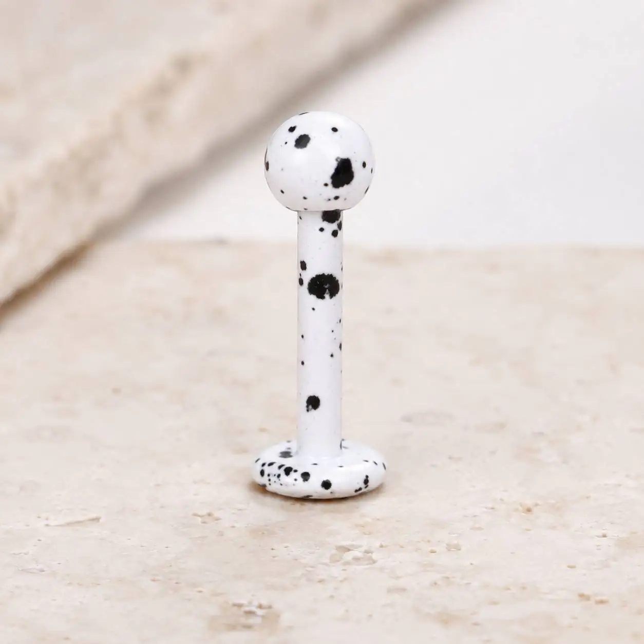 white-black-speckled-labret-piercing-front-view پیرسینگ لب لبرت سفید خالمشکی با گوی گرد و انتهای تخت