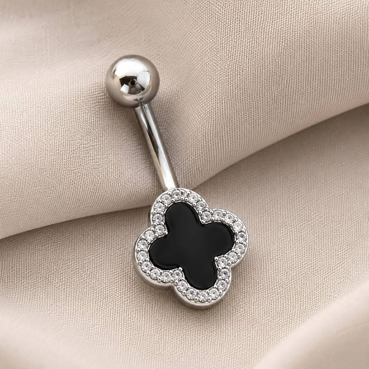black-clover-belly-ring-velvet نگین ناف شبدر چهارپر مشکی با میله منحنی نقرهایرنگ روی پارچه