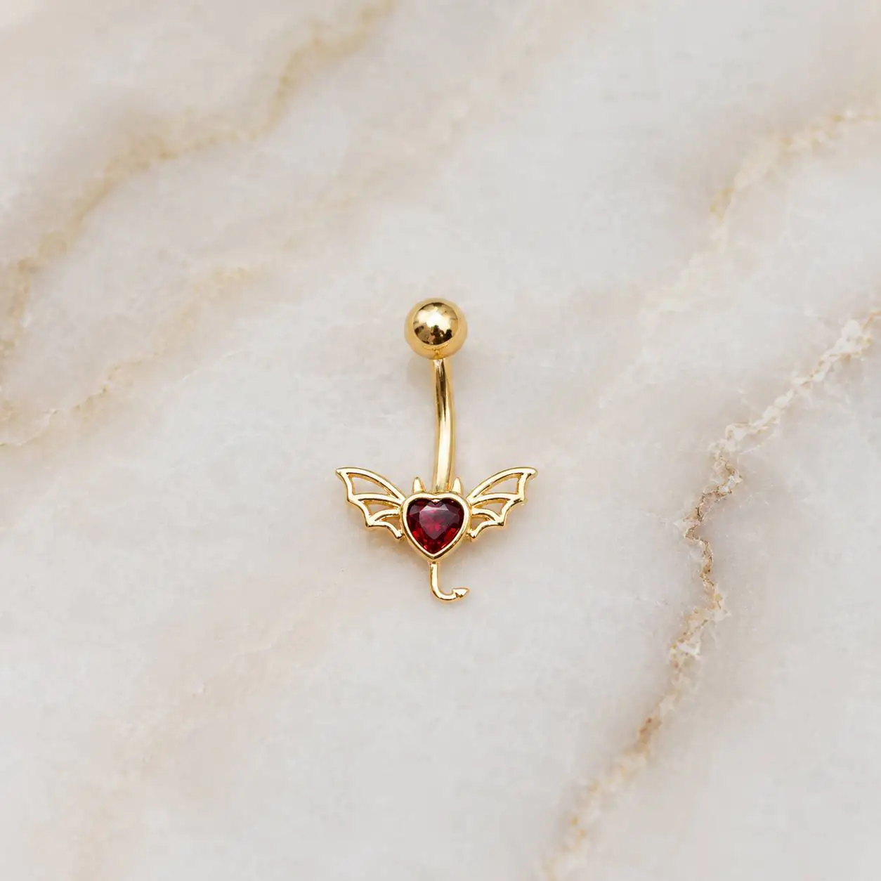 devil-heart-belly-button-piercing پیرسینگ ناف طرح قلب شیطانی قرمز با بال خفاش و دم خمیده