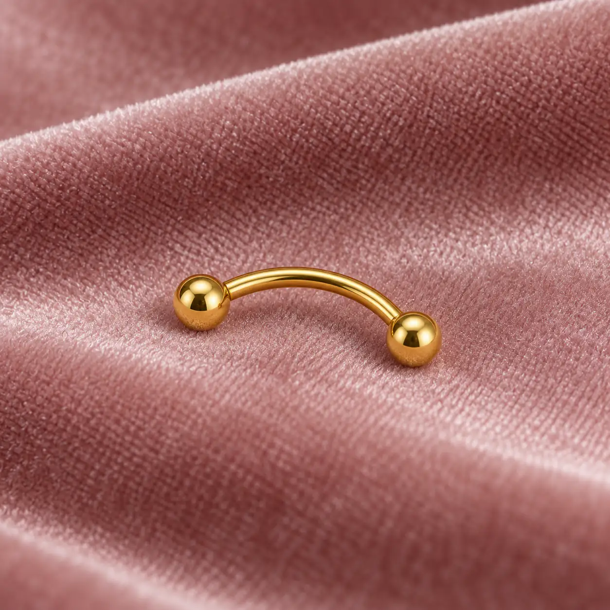 gold-curved-eyebrow-barbell-close.webp پیرسینگ ابرو طلایی ساده با میله خمیده و دو گوی نمای نزدیک