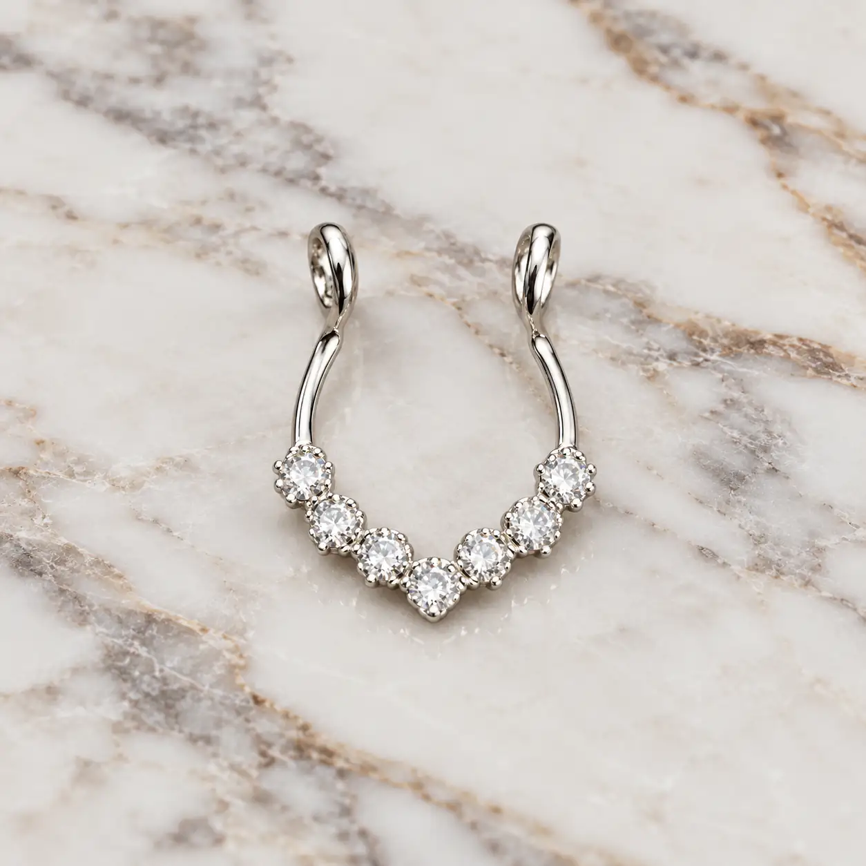 silver-crystal-fake-septum-marble.webp نمای کامل پیرسینگ فیک سپتوم نقرهای با ردیف نگینهای شفاف