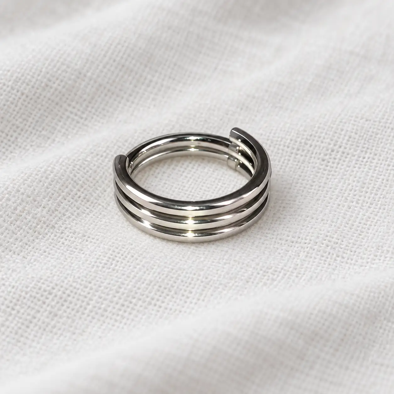 triple-band-nose-ring-cotton.jpg پیرسینگ بینی سهردیفه نقرهای روی پارچه نخی سفید
